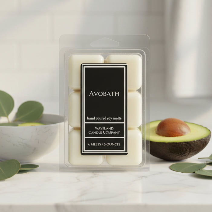 A package of six hand-poured soy melts in a clear plastic clamshell container with a black label reading 'Avobath' and 'Waveland Candle Company'. The melts are a warm cream color, and the background is a clean, neutral gray studio backdrop.